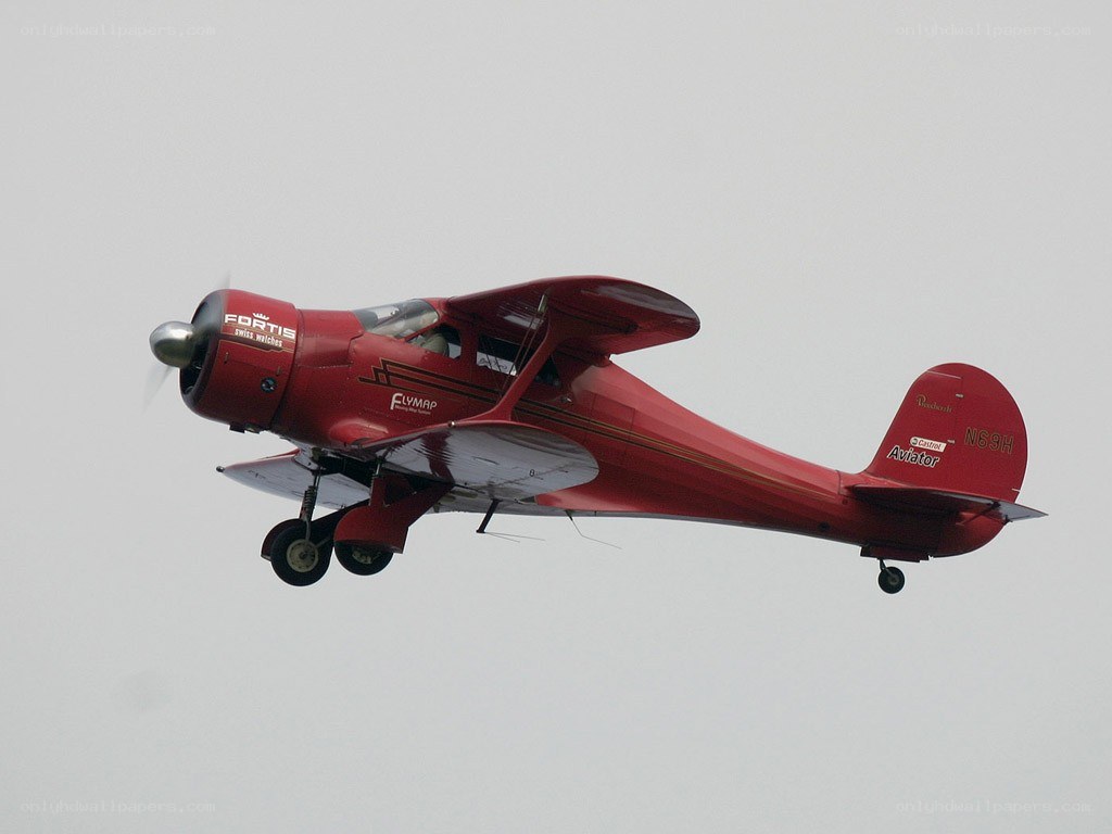 Red vintage biplane in flight