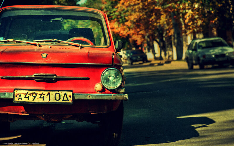 Red vintage car on a tree-lined street