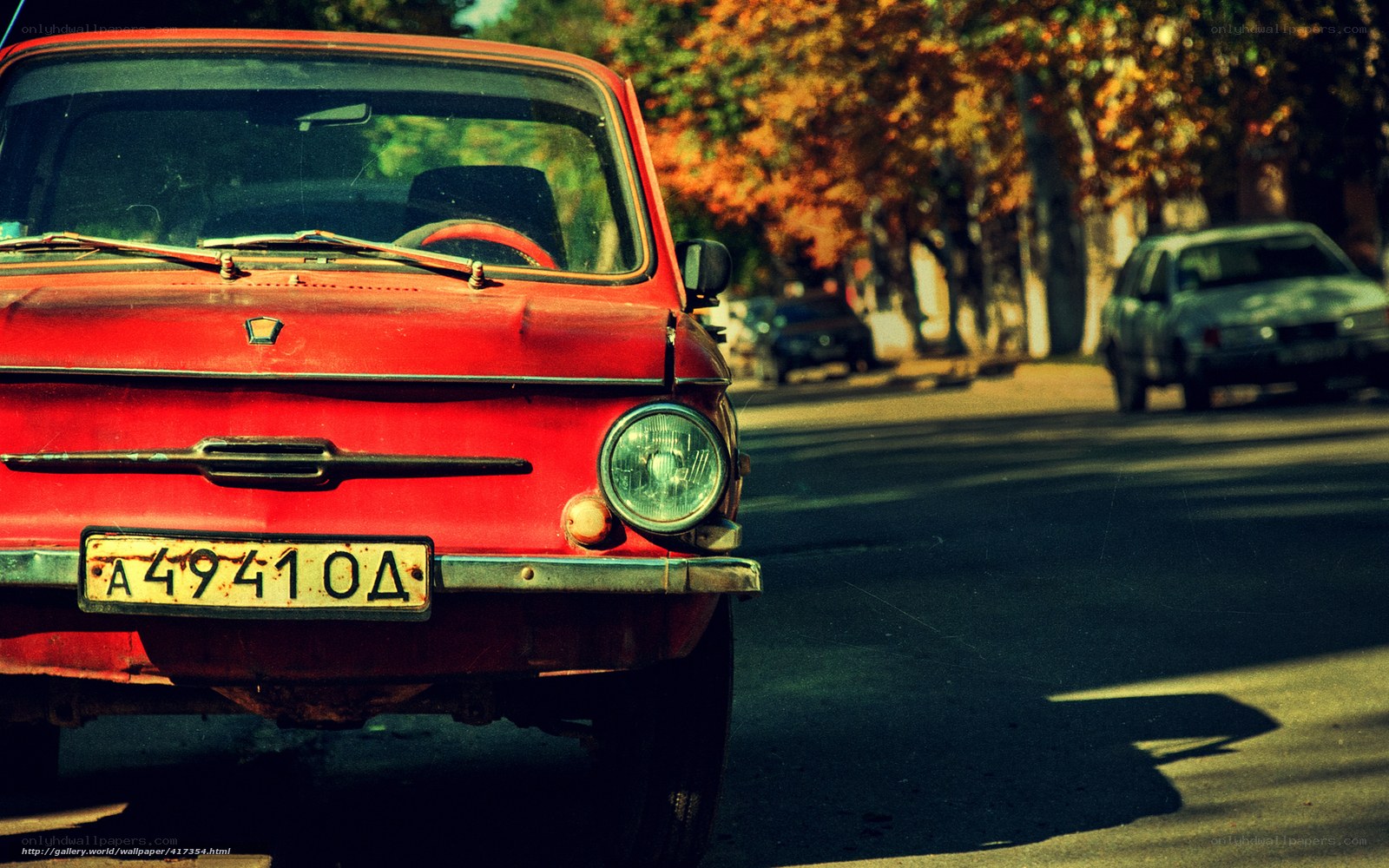 Red vintage car on a tree-lined street