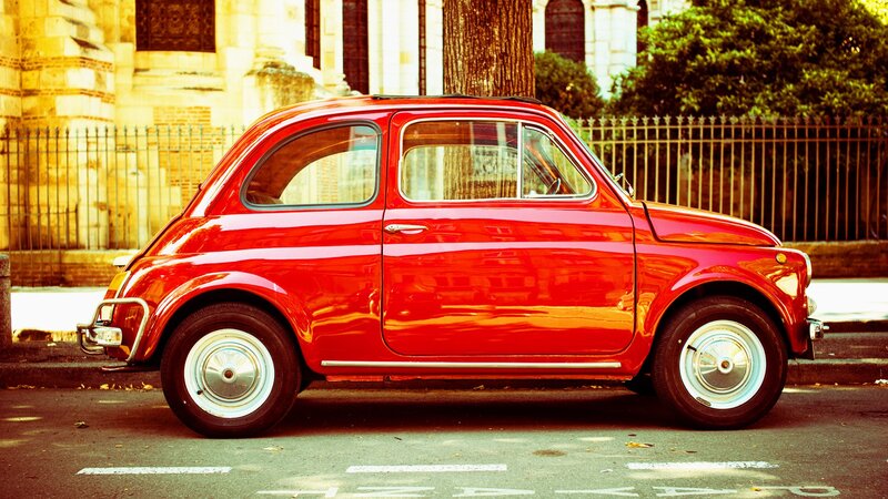 Red vintage car on city street