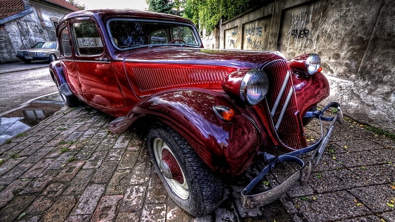 Red vintage car on cobblestone