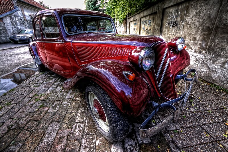Red vintage car on cobblestone street