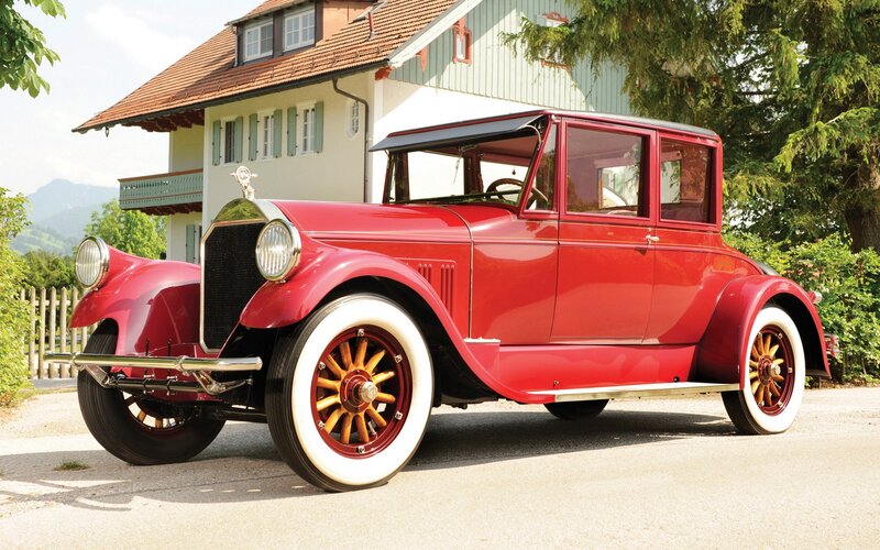 Red vintage car parked outside house