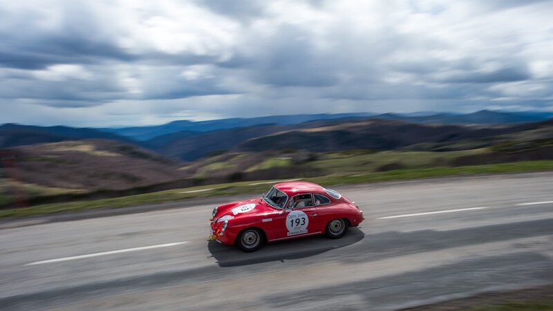 Red vintage car racing on mountain road