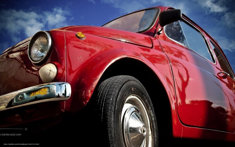 Red vintage car under blue sky