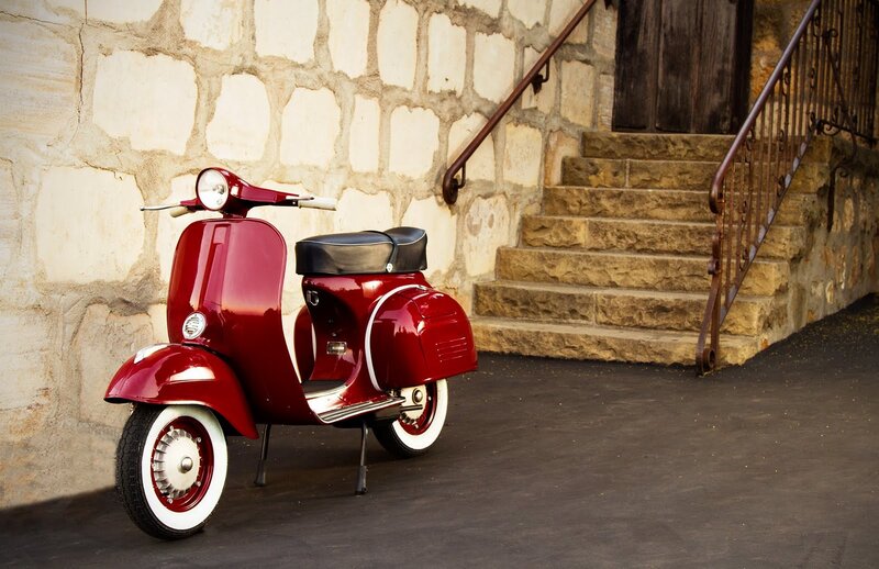 Red vintage scooter by stone stairs