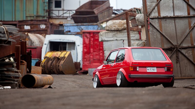 Red Volkswagen Golf in junkyard