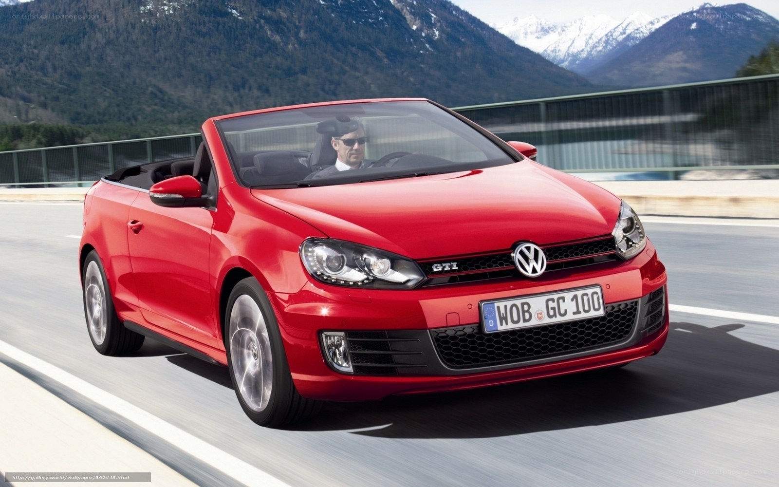 Red Volkswagen GTI convertible on road