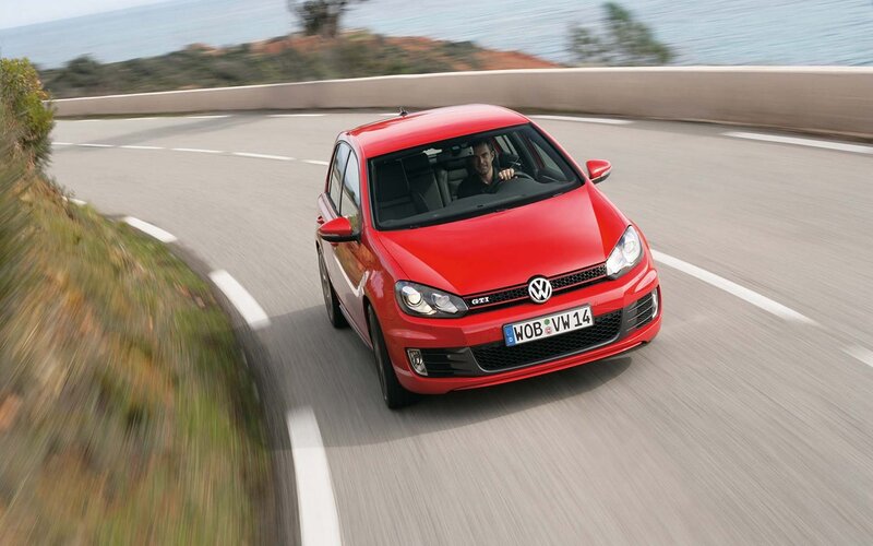 Red Volkswagen GTI on coastal road