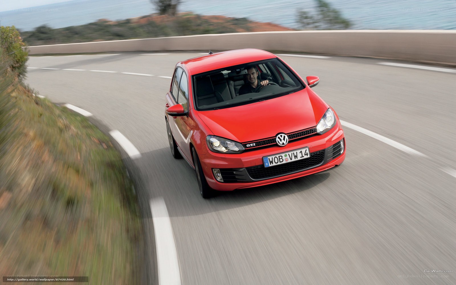 Red Volkswagen GTI on coastal road