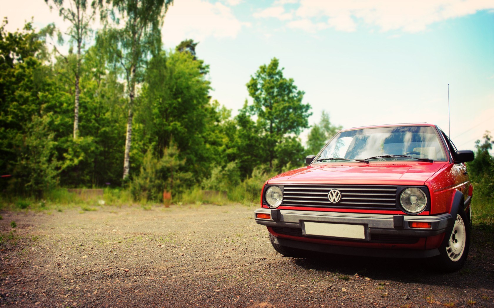 Red Volkswagen in a forest clearing