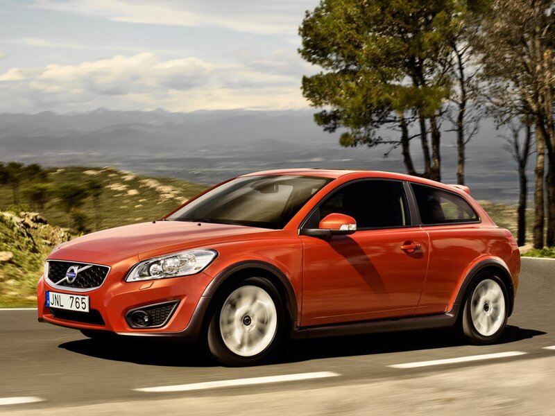 Red Volvo C30 driving on a road
