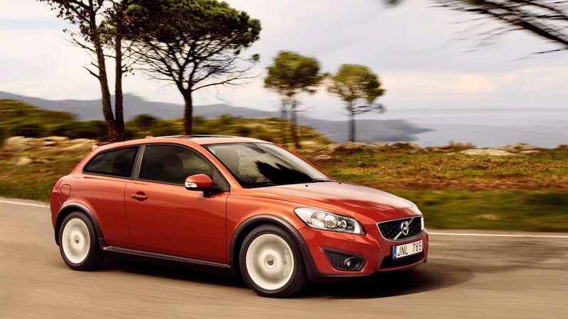 Red Volvo C30 driving on coastal road