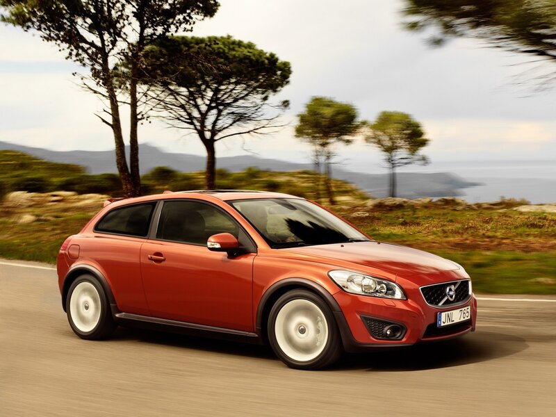 Red Volvo C30 driving on coastal road