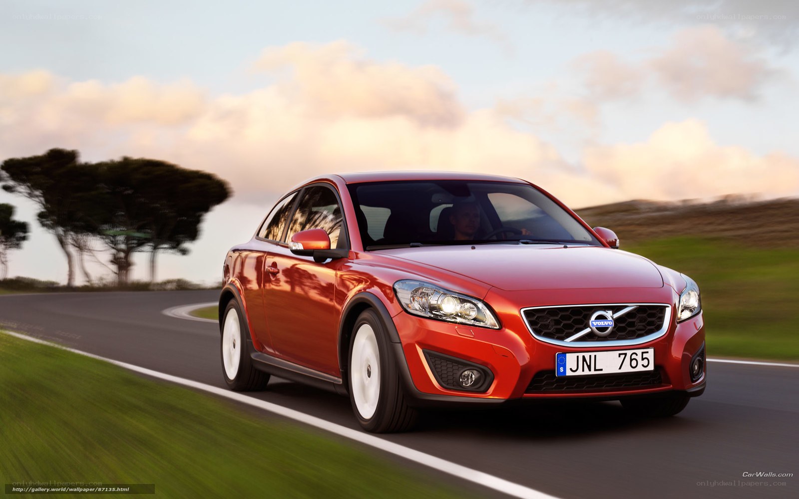 Red Volvo C30 driving on road