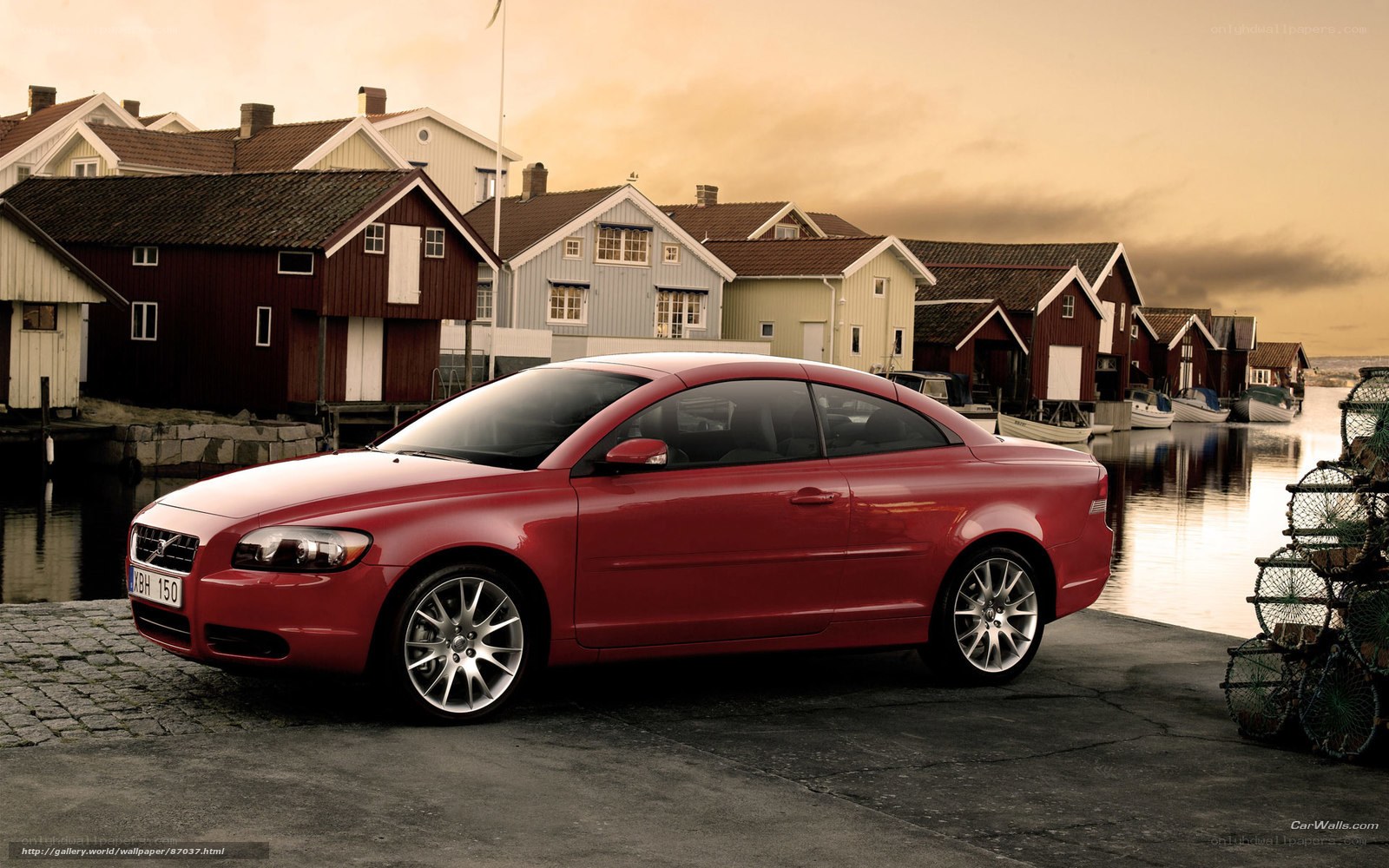 Red Volvo C70 by a harbor