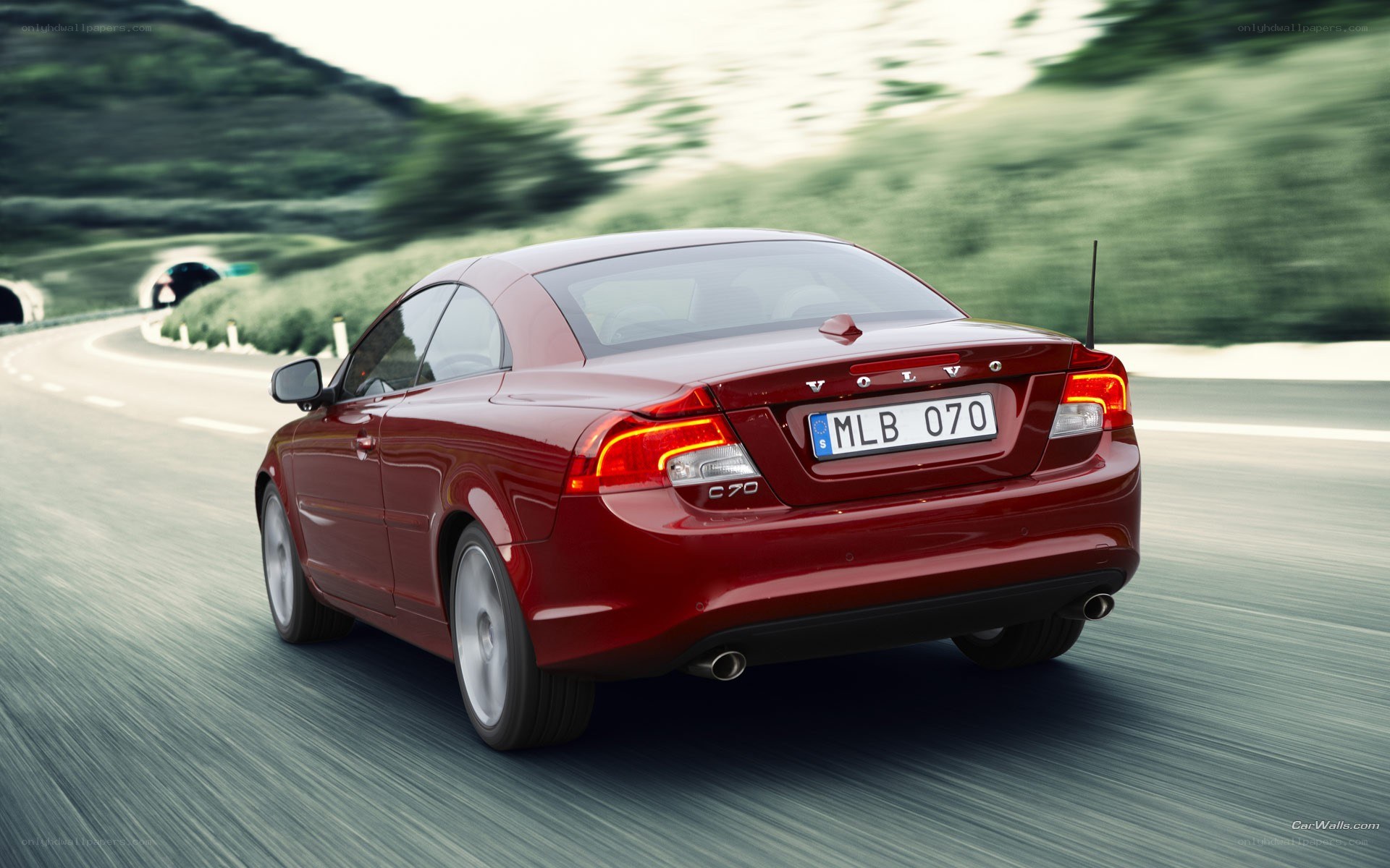 Red Volvo C70 driving on road