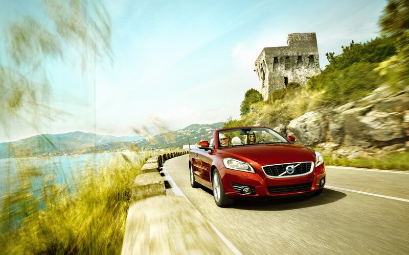 Red Volvo convertible on coastal road