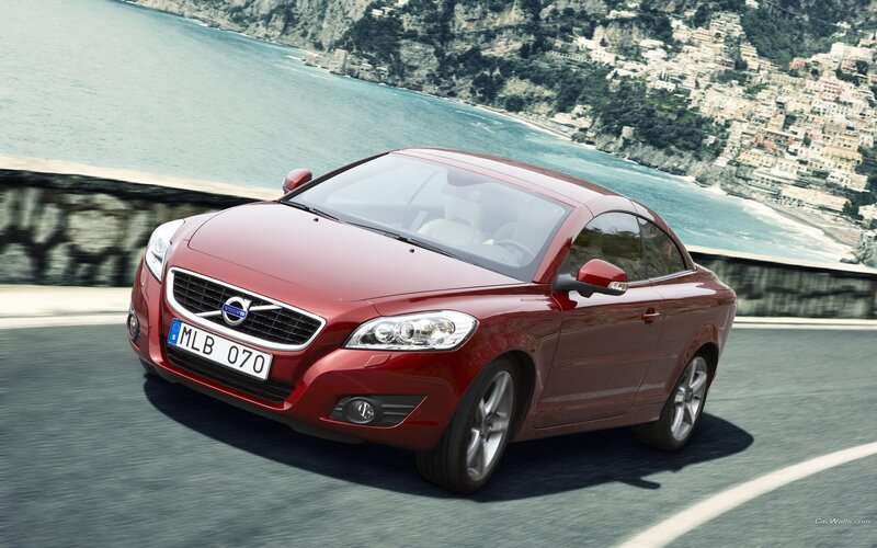 red volvo coupe on coastal road