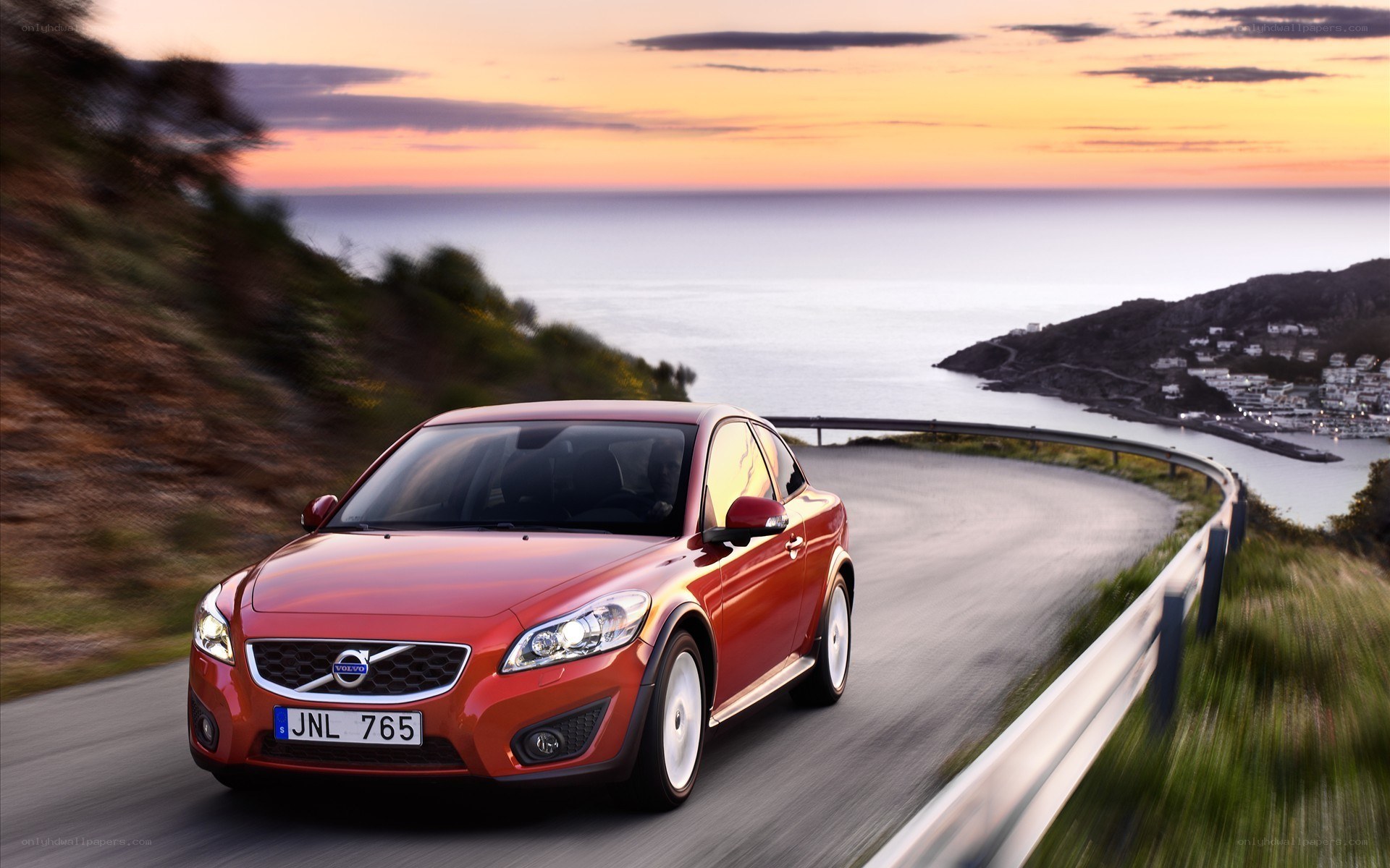 Red Volvo on coastal road