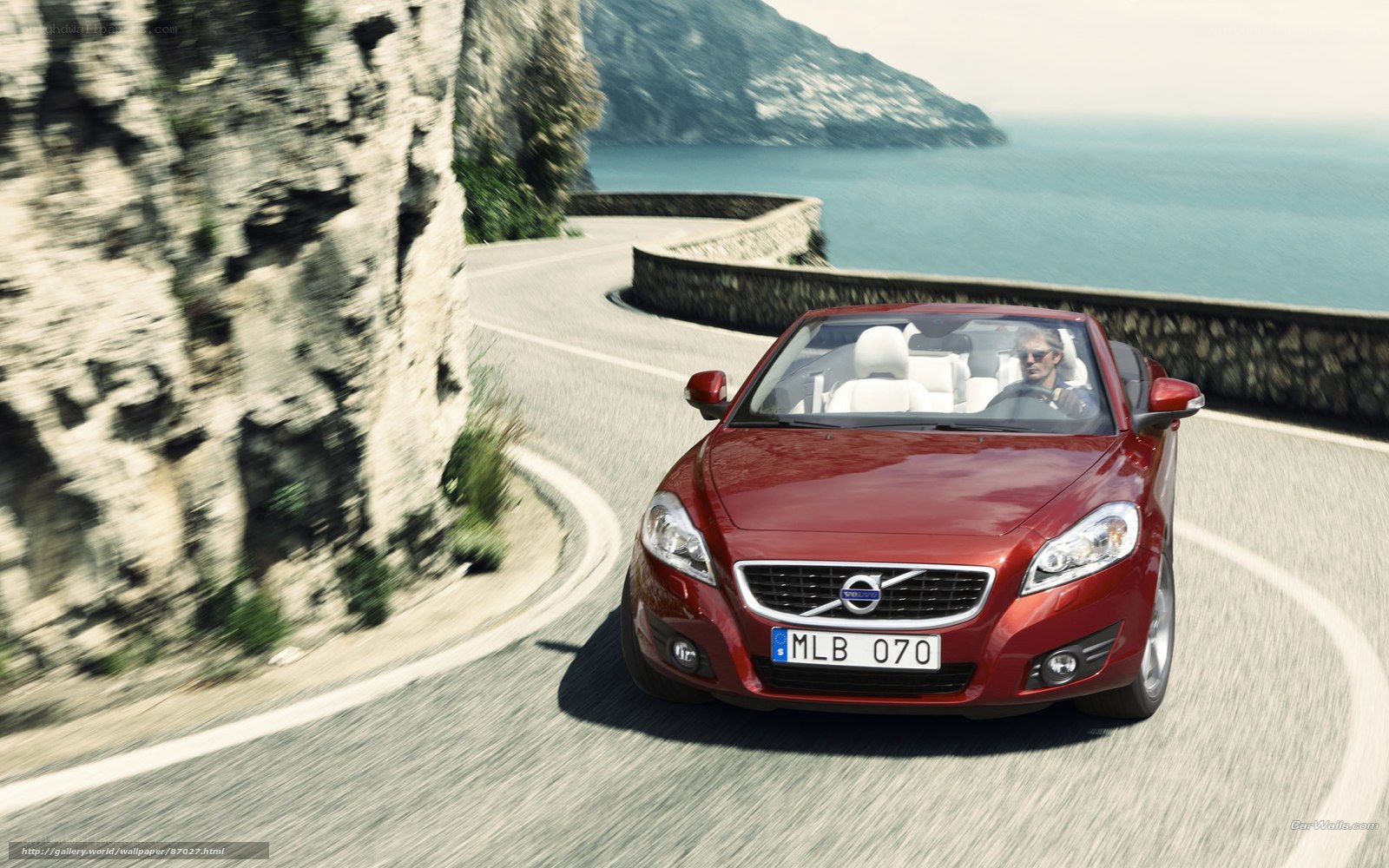 Red Volvo on coastal road