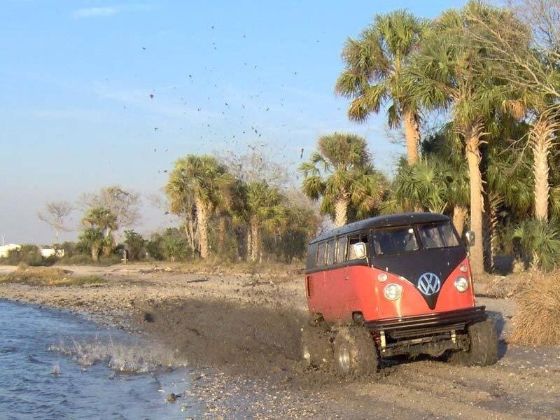 Red VW bus on muddy beach