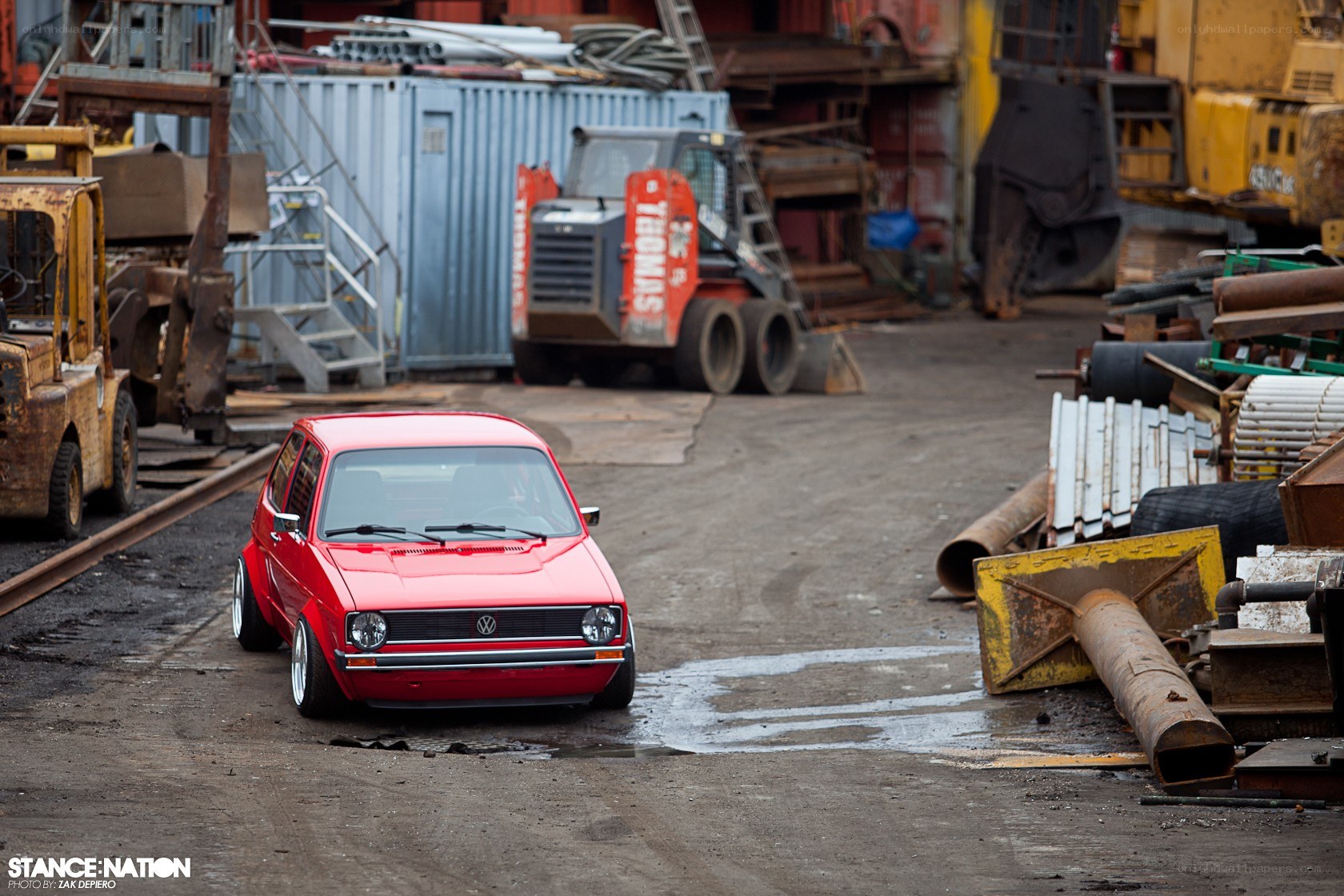 Red VW Golf in industrial yard