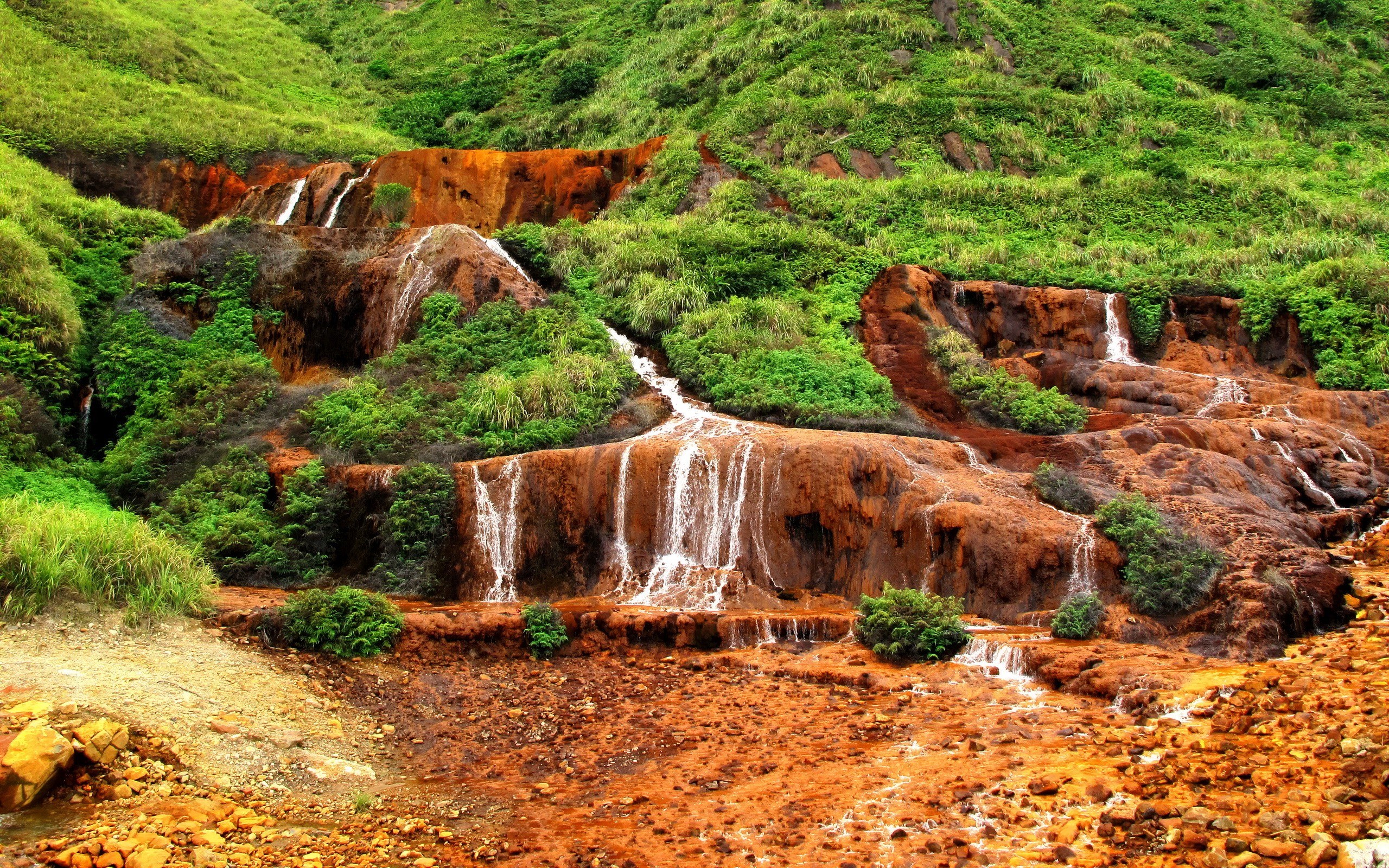 Red waterfall in green hills