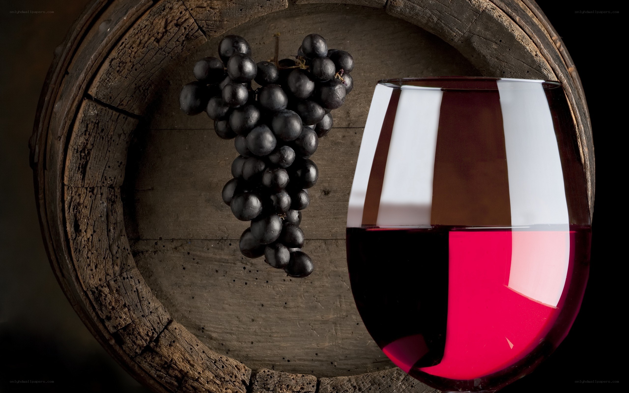 red wine and grapes on barrel