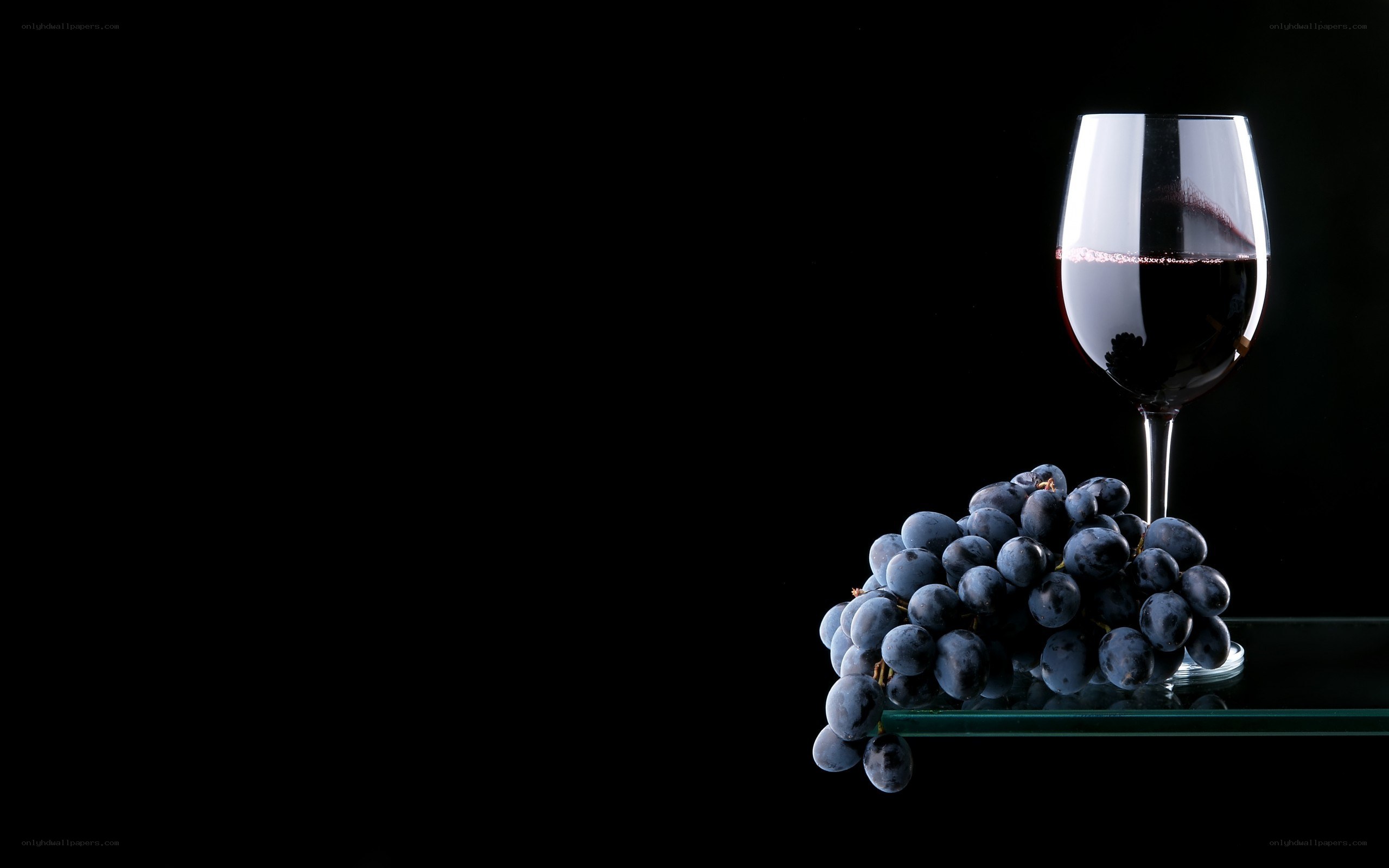 Red wine and grapes on black
