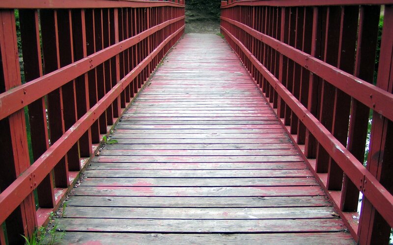 red wooden bridge over stream