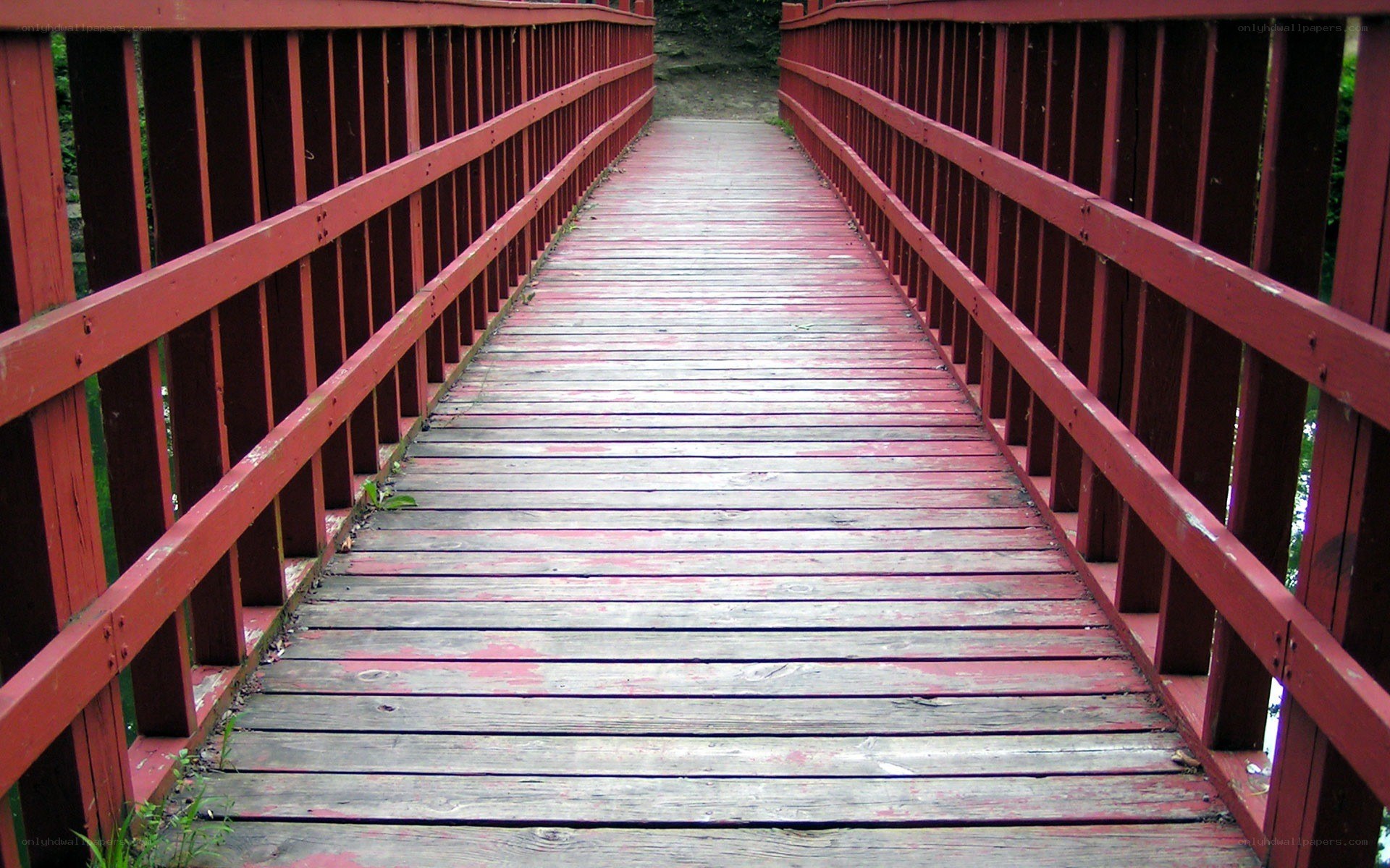red wooden bridge over stream