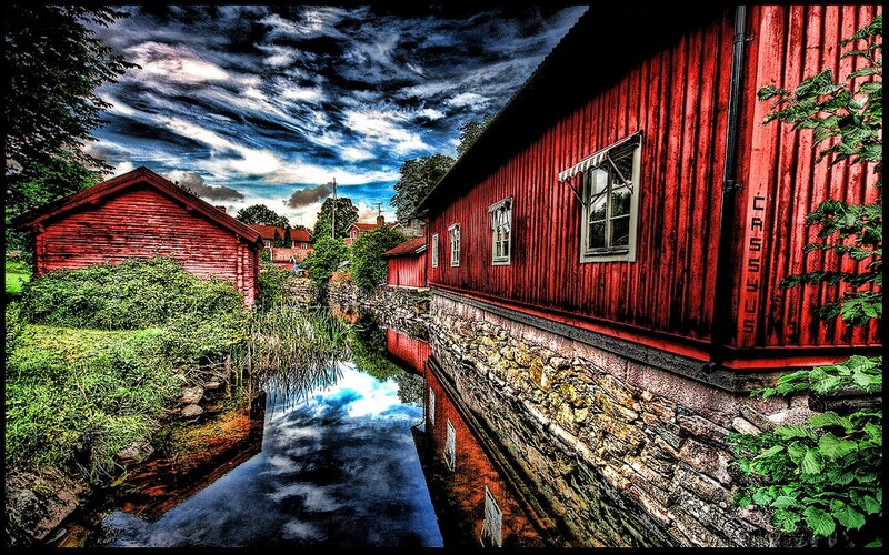 Red wooden buildings by a canal