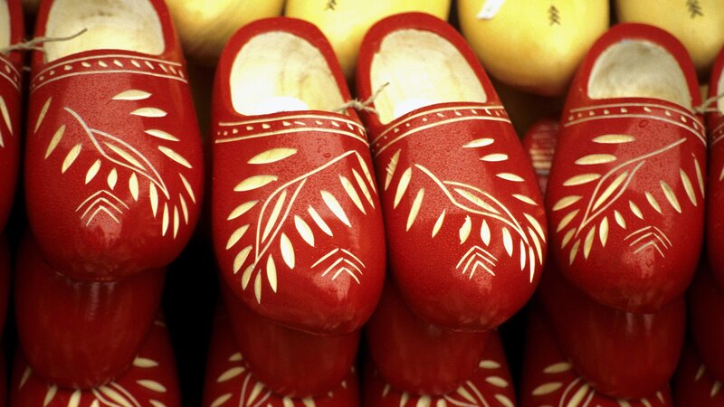 Red wooden clogs with leaf patterns