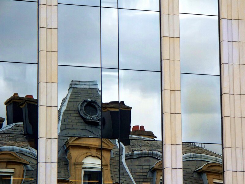 Reflection of historic buildings in glass