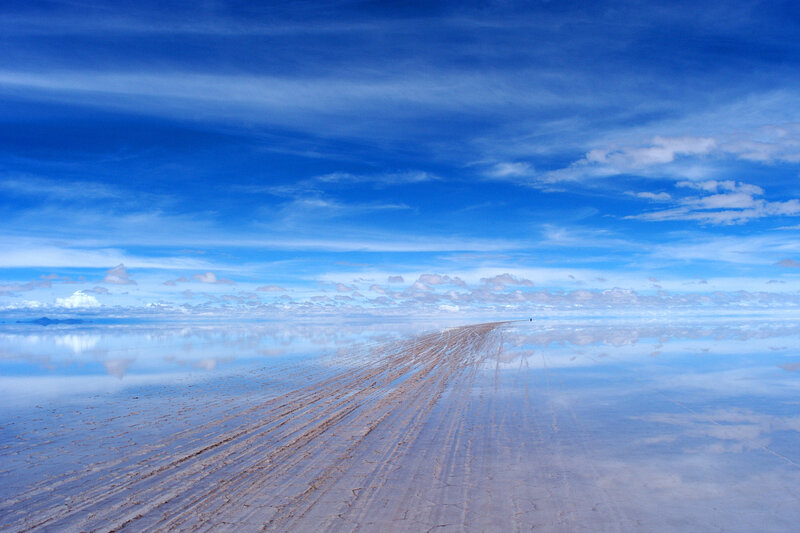 Reflective salt flat under blue sky