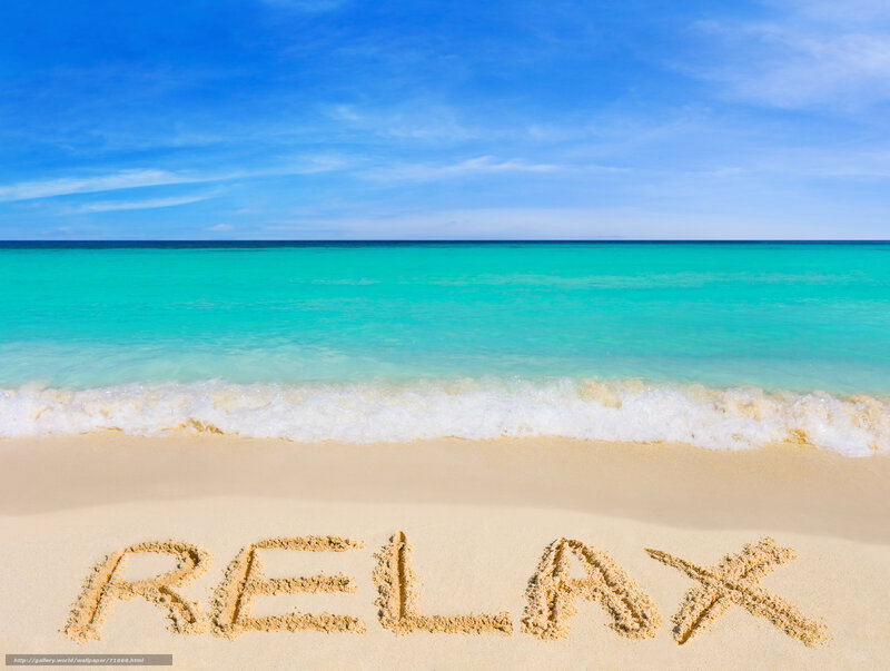 Relax written in sand on a tropical beach