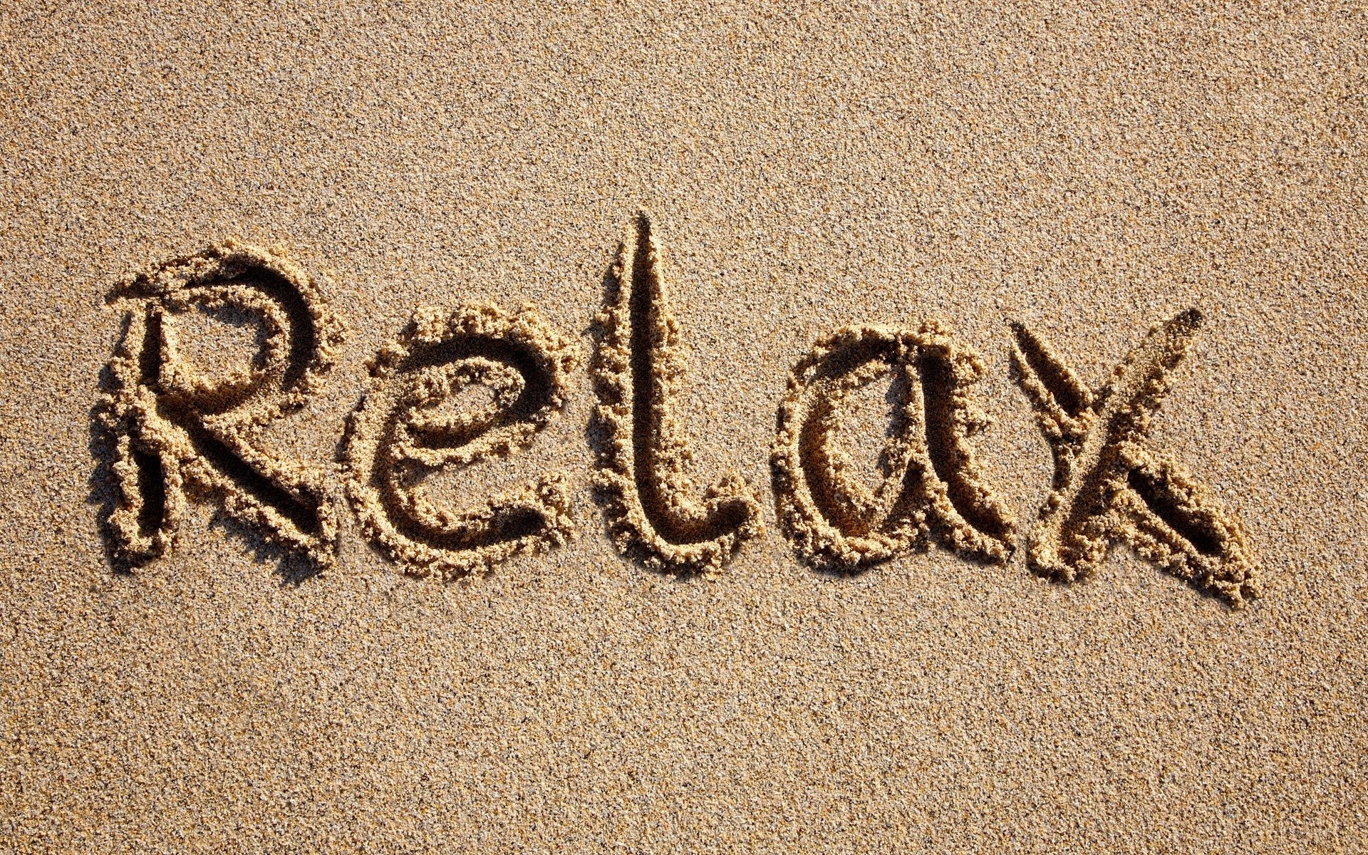 Relax written in sand