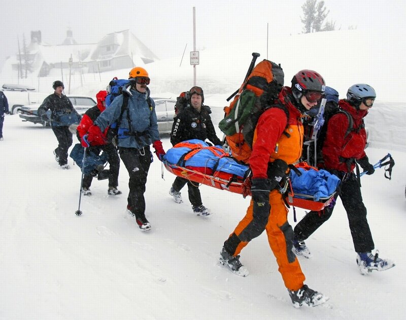 Rescue team carries stretcher in snow