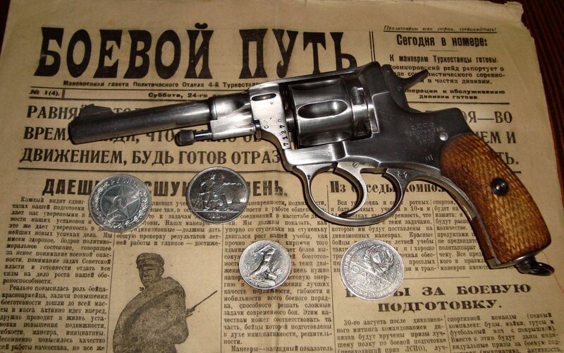 Revolver on newspaper with coins