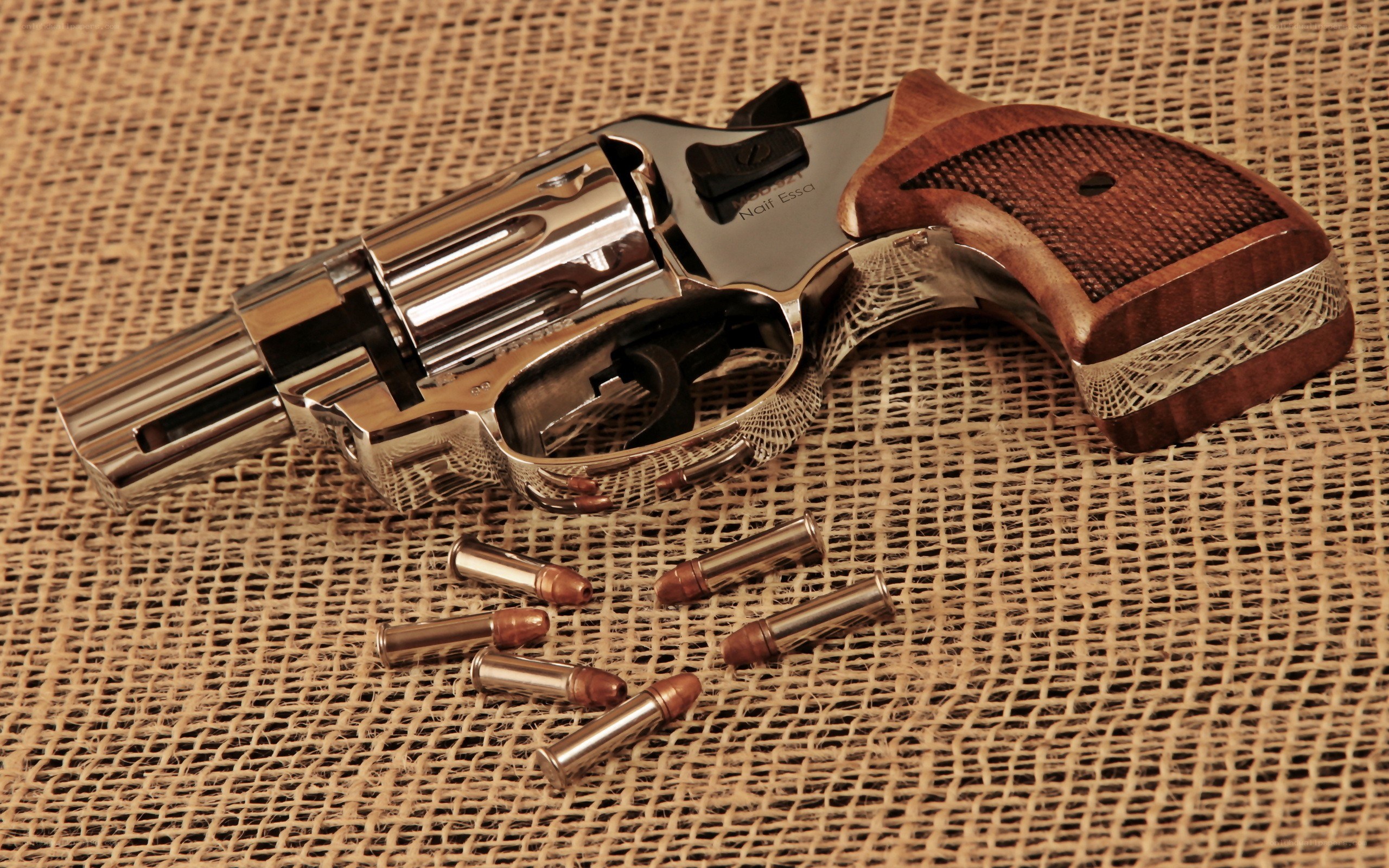 revolver with bullets on burlap