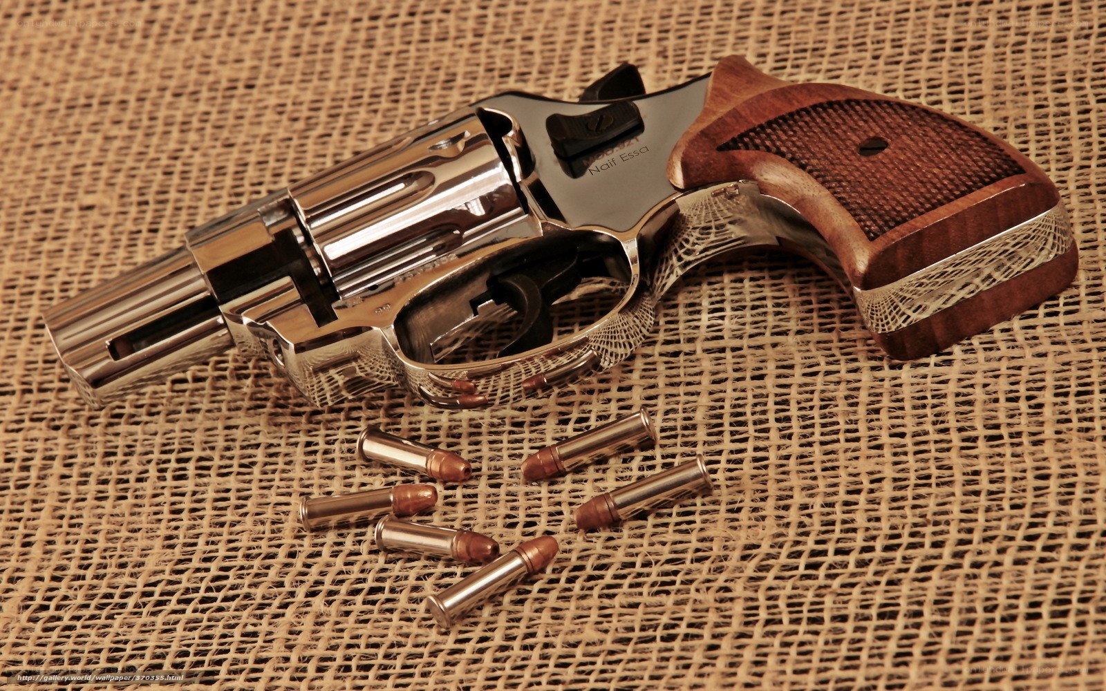 revolver with bullets on burlap