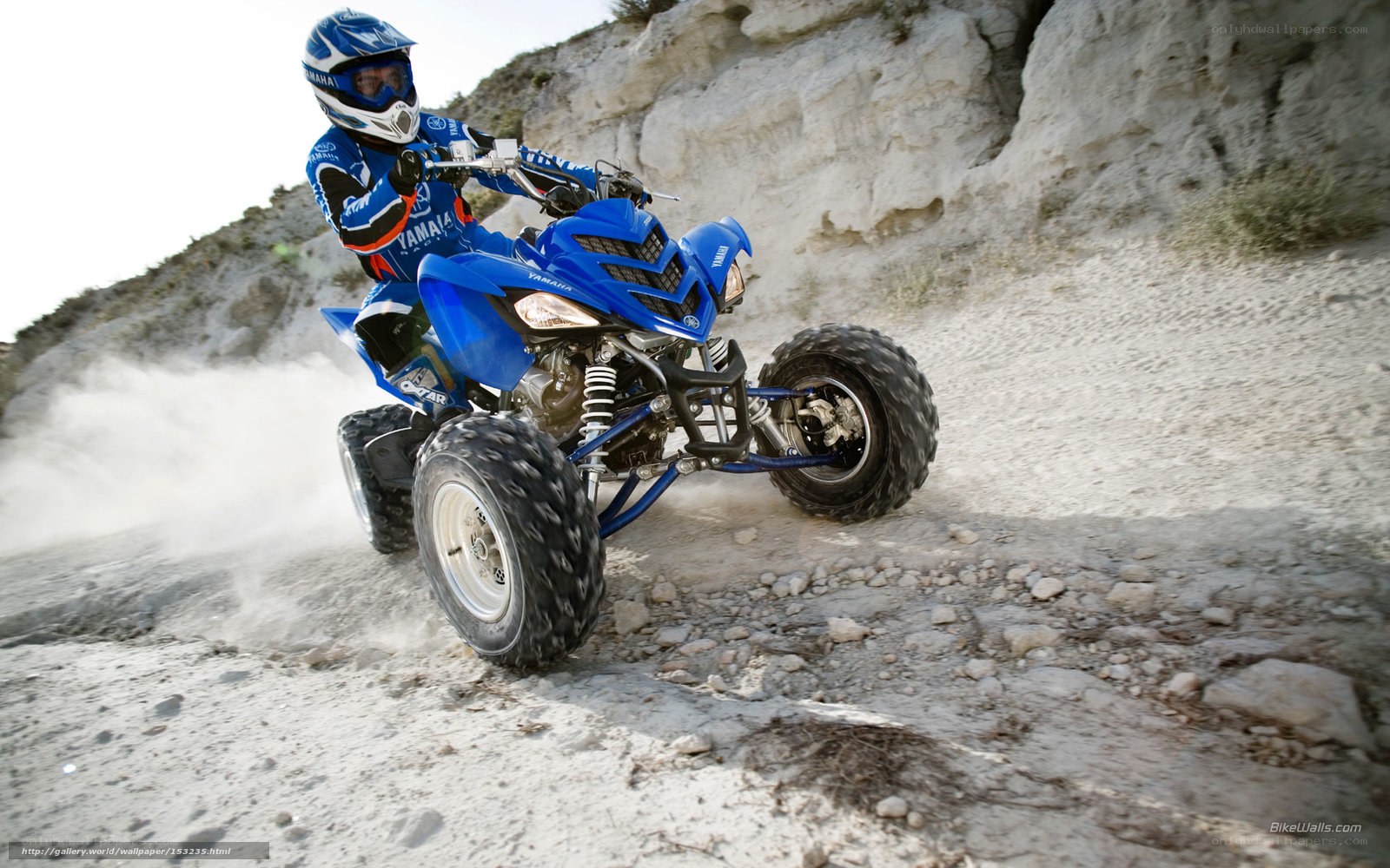 Riding a blue ATV on a dirt path