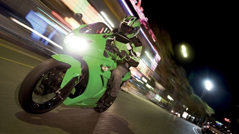 Riding a green motorcycle at night