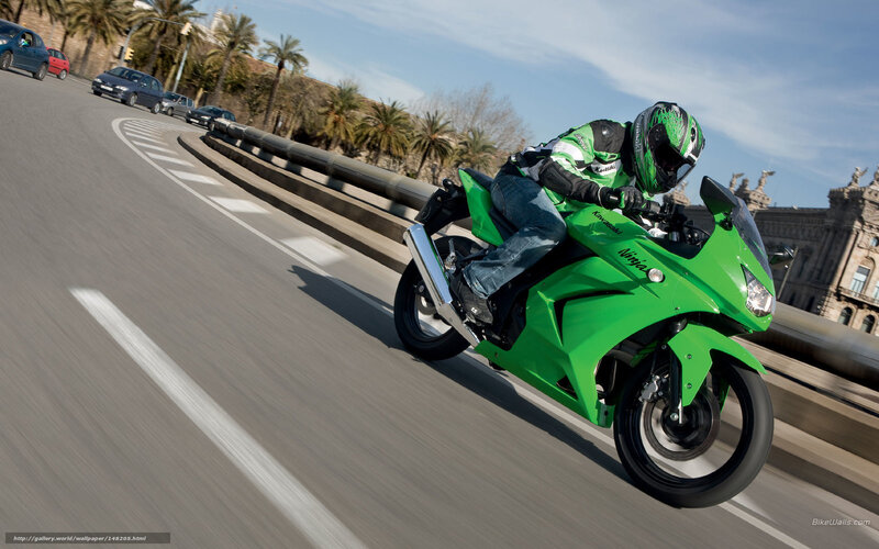 Riding a green motorcycle on a bridge