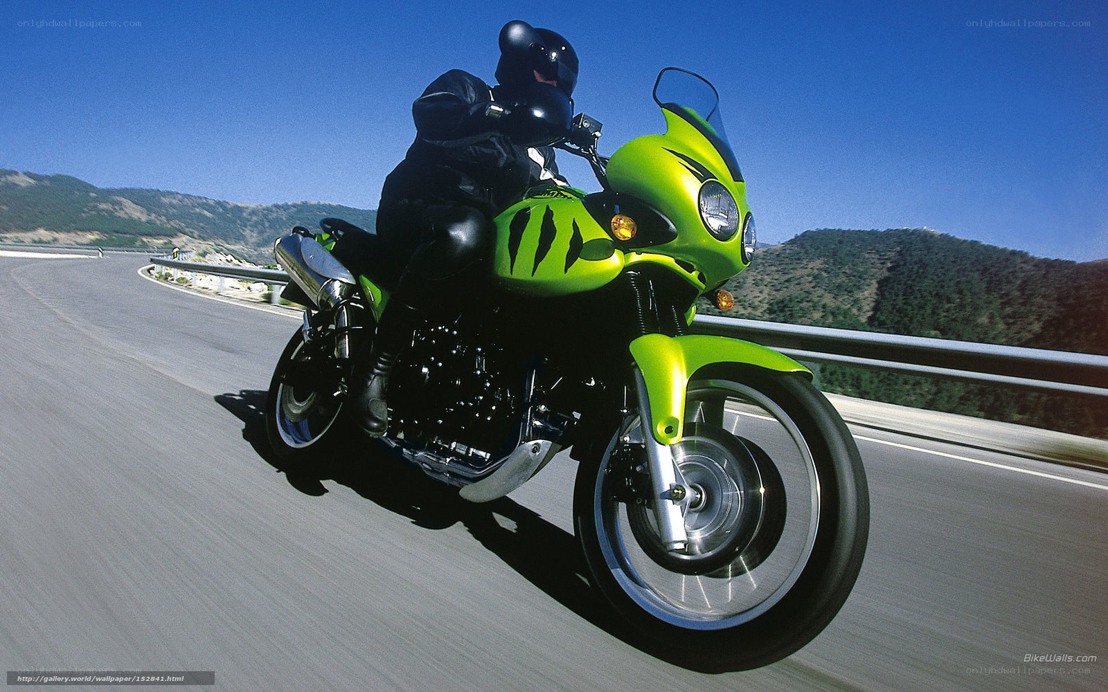 Riding a green motorcycle on a road