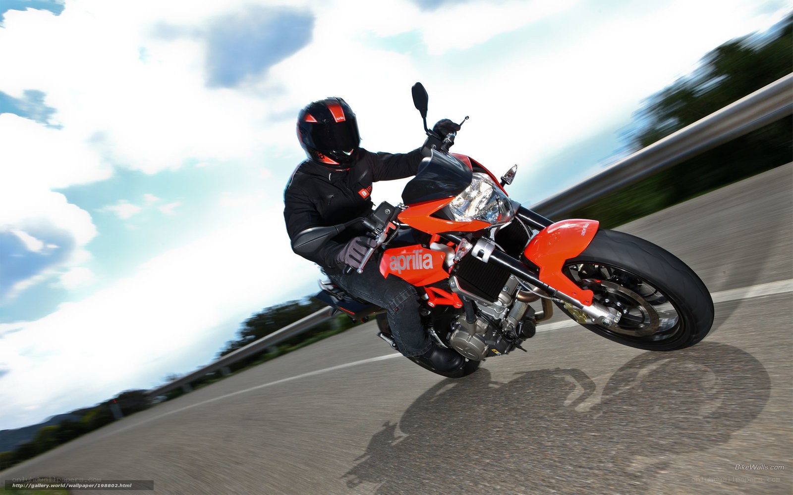 Riding a red Aprilia motorcycle