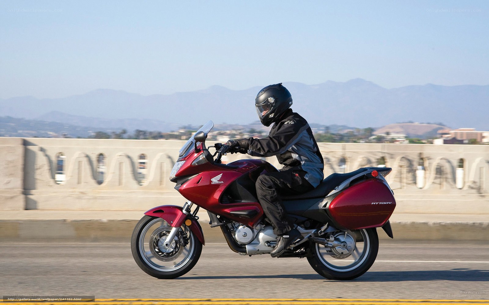 Riding a red Honda motorcycle