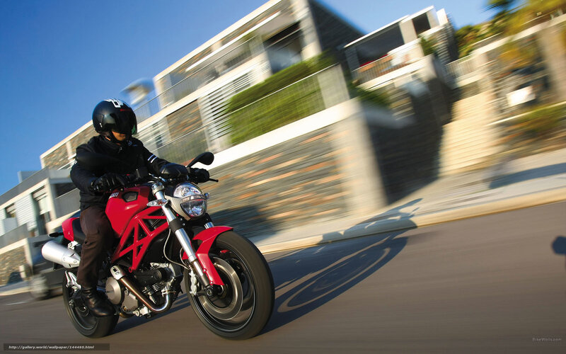 Riding a red motorcycle on a city street