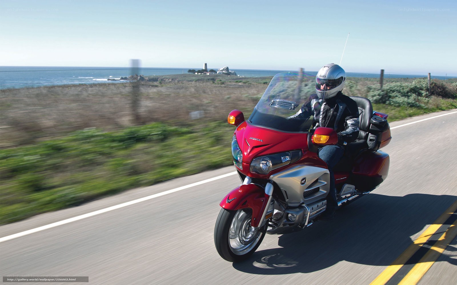 Riding a red motorcycle on a coastal road